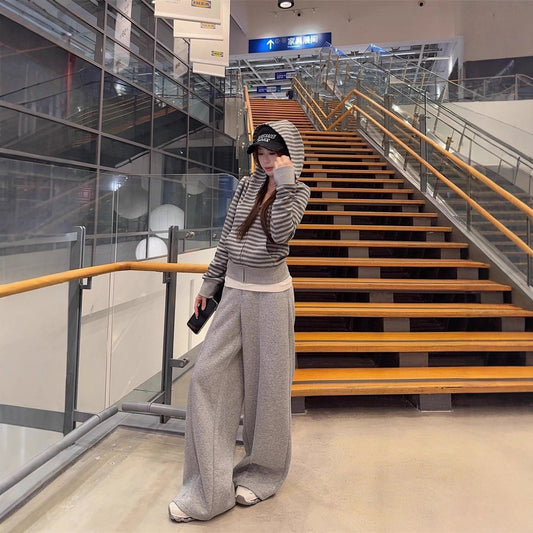 Women's loose-fitting striped gray hooded sweater with a striped design.