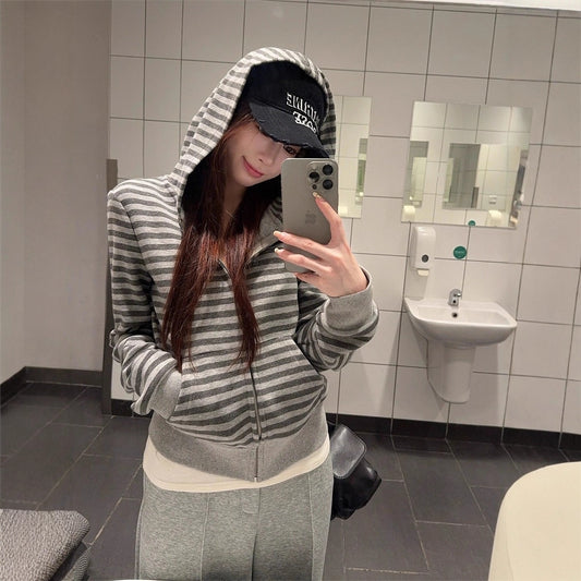 Women's loose-fitting striped gray hooded sweater with a striped design.